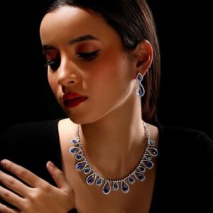 woman wearing blue stone brass rhodium jewellery set elegant necklace and earrings