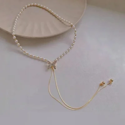 close up silver butterfly pendant on gold chain necklace