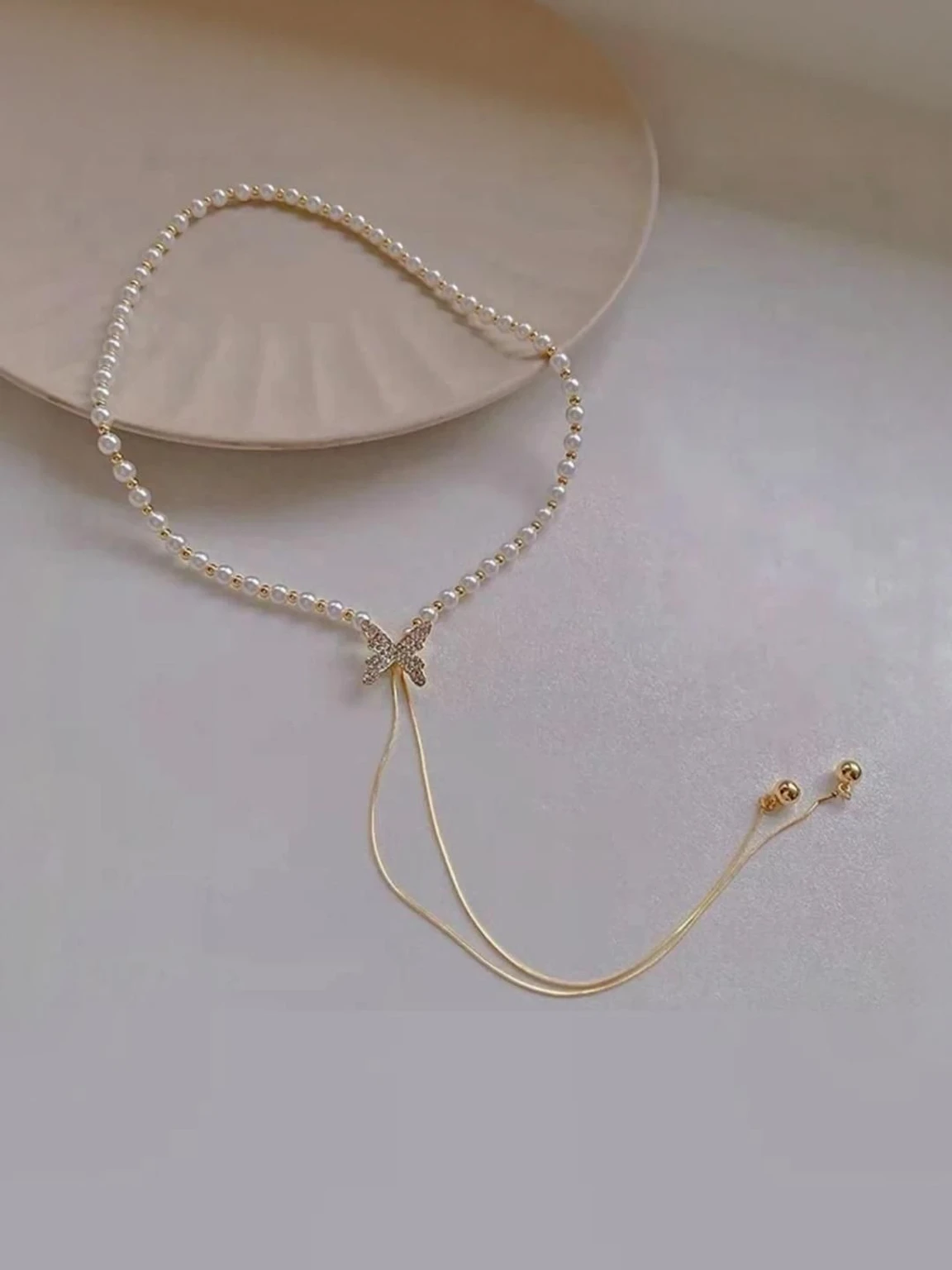 close up silver butterfly pendant on gold chain necklace